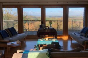 A beautiful peaceful room set up for a workshop in the way of the horse, with low sunlight streaming through the glass windows. Outside is a view of the hills in Wales UK