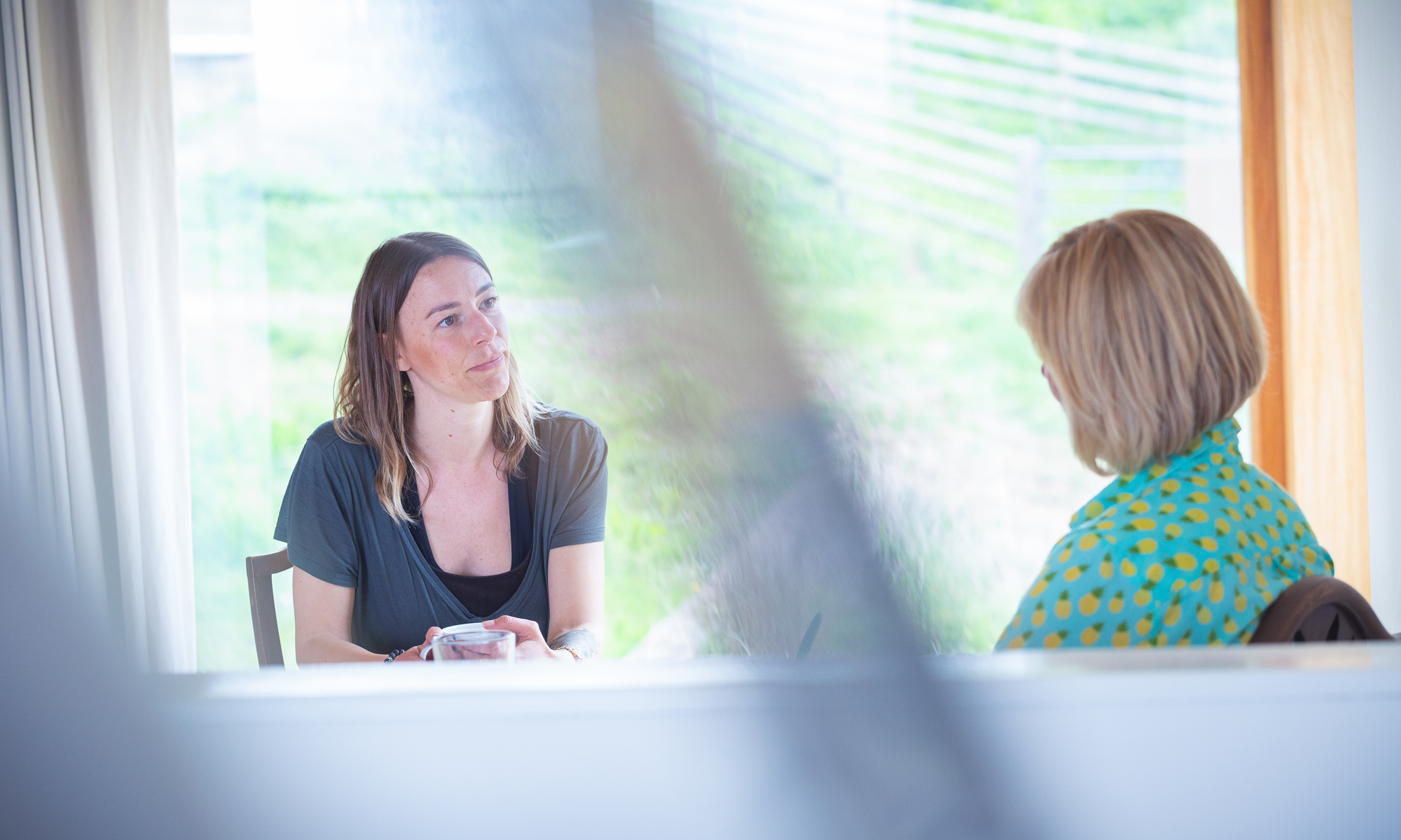 A photo of Abby having a coaching session with Rosie. Abby is looking thoughtful. Abby enrolled on Rosie's NOW Programme partly because she knew she needed to make changes in her life for her own happiness.