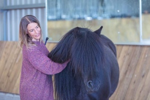 woman petting a horse at an equine facilitated workshop somerset uk