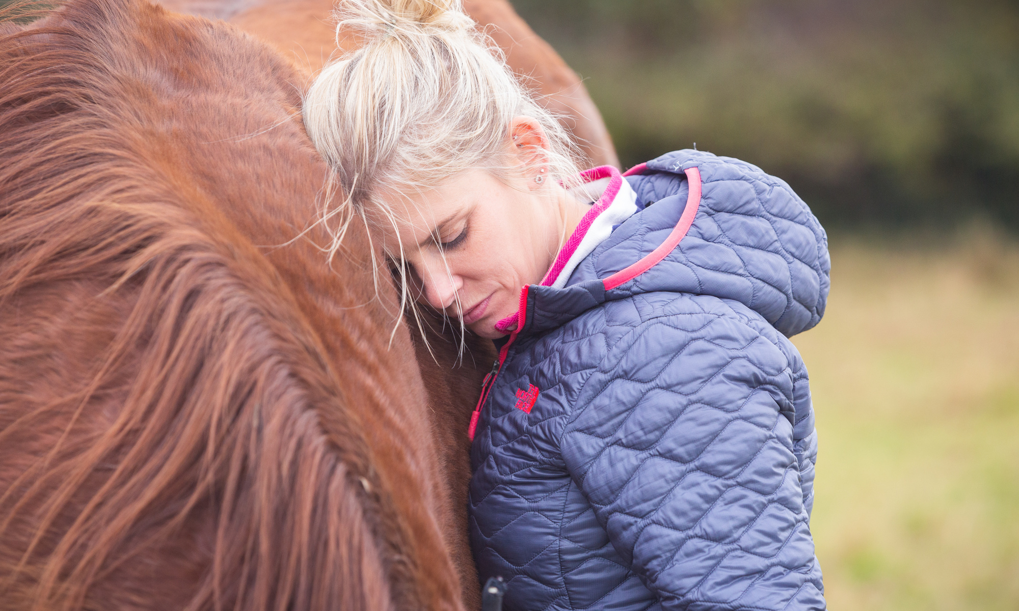 Workshop client, Lauren is resting her head on Jack's neck. Jack is Rosie's chestnut horse.